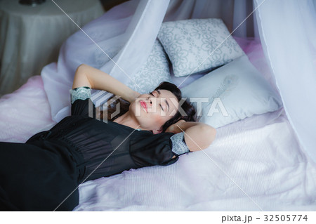 Pretty brunette woman lies on bed 32505774