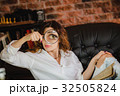 funny woman looking through a magnifying glass 32505824