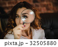 funny woman looking through a magnifying glass 32505880