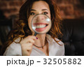 funny woman smiling and show teeth through a 32505882