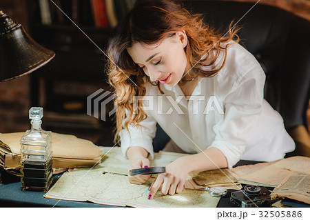 funny woman looking through a magnifying glass to 32505886