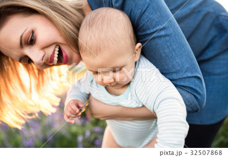 Young mother in nature with baby son in the arms. Young mother in nature with baby son in the arms. 32507868