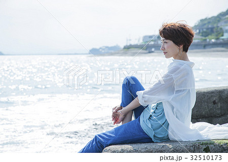 海 散歩 女性 旅行 観光 防波堤 海辺 リラックスの写真素材