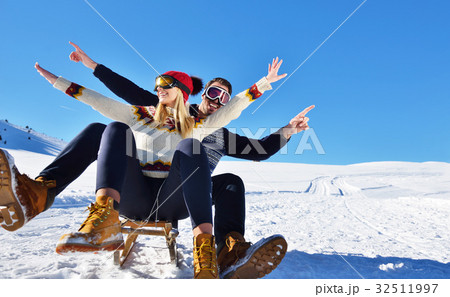 Young Couple Sledding And Enjoying On Sunny Winter Young Couple Sledding And Enjoying On Sunny Winter 32511997