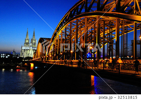 ドイツ 夜のケルン大聖堂とホーエンツォレルン橋の写真素材