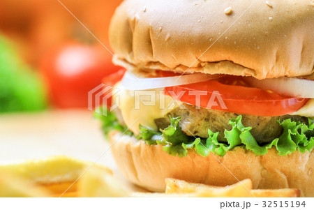 Burger on wooden plate with french fries Burger on wooden plate with french fries 32515194
