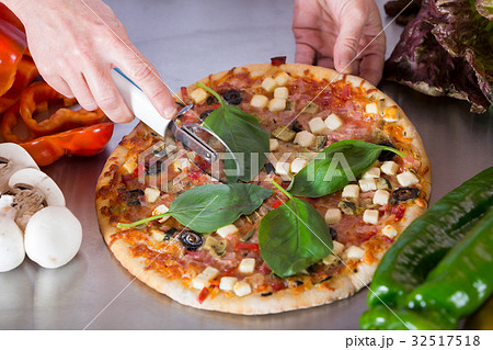 Cook cutting a pizza 32517518