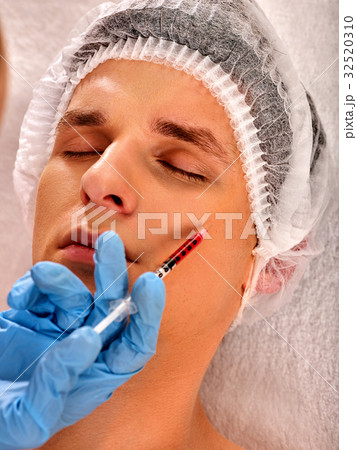 Dermal fillers of man in spa salon with beautician Dermal fillers of man in spa salon with beautician 32520310