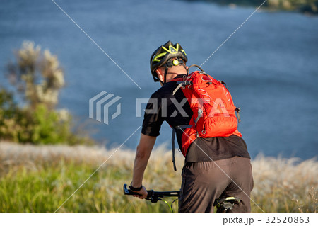Young man riding mountain bike on the green meadow 32520863