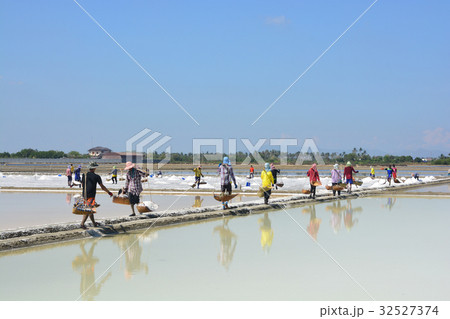 Worker shoveling salt at salt pan at Thailand Worker shoveling salt at salt pan at Thailand 32527374