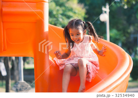 Cute asian child girl having fun to play slider Cute asian child girl having fun to play slider 32534940