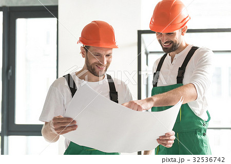 Beaming male constructors discussing project Beaming male constructors discussing project 32536742