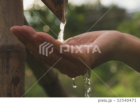 Water pouring in woman hand on nature background. Water pouring in woman hand on nature background. 32540471