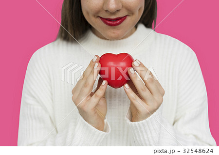 Smiling girl holding a res heart 32548624