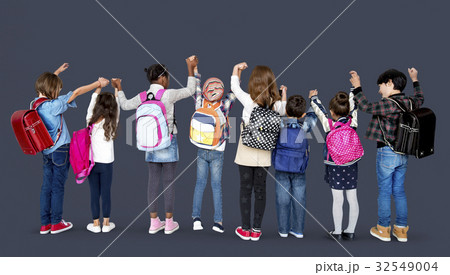 Rear view group of diverse kids standing in a row holdings hands in the air Rear view group of diverse kids standing in a row holdings hands in the air 32549004