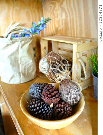 Pine cones in wooden bowl decorated on shelf 32554571