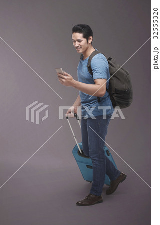 Traveler asian man with backpack using smartphone Traveler asian man with backpack using smartphone 32555320