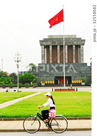Vietnamese woman riding a bicycle and Ho Chi Min m 32558082