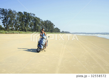 Tanned brunette rides on a deserted beach 32558572