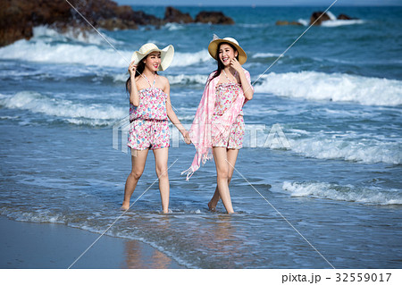 Two women Wearing a hat walking enjoy Two women Wearing a hat walking enjoy 32559017