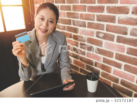 Woman using credit card and digital tablet Woman using credit card and digital tablet 32572187