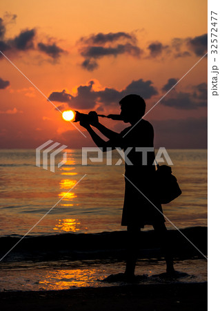 Silhouettes of photographers with the sunrise. Silhouettes of photographers with the sunrise. 32572477