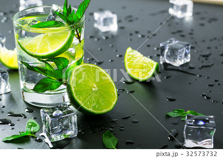 Mojito cocktail with lime, ice cubes and mint Mojito cocktail with lime, ice cubes and mint 32573732