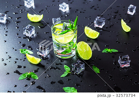 Mojito cocktail with lime, ice cubes and mint Mojito cocktail with lime, ice cubes and mint 32573734