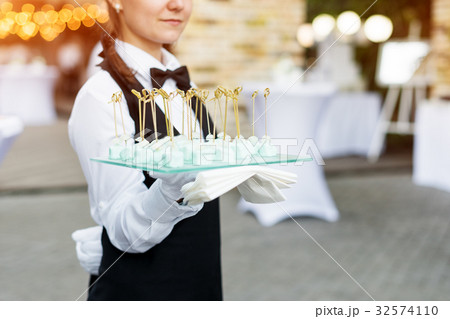 Catering service. Waiter carrying a tray of Catering service. Waiter carrying a tray of 32574110