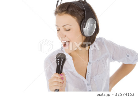 Caucasian female singing into microphone. 32574152
