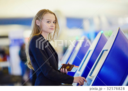 Young business woman doing self check-in in international airport terminal Young business woman doing self check-in in international airport terminal 32576828