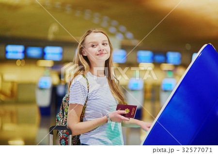 Tourist girl with backpack and carry on luggage in international airport, doing self check-in 32577071