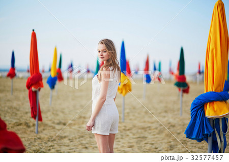 Beautiful young woman with famous colorful parasols on Deauville Beach Beautiful young woman with famous colorful parasols on Deauville Beach 32577457