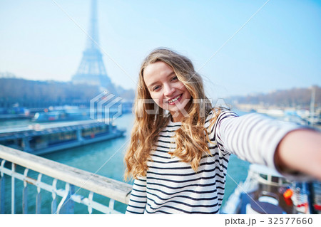 Young girl taking selfie near the Eiffel tower Young girl taking selfie near the Eiffel tower 32577660