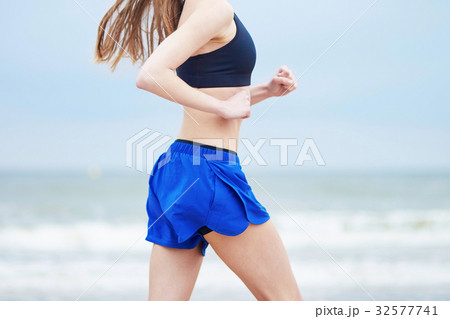 Young fitness running woman jogging on beach Young fitness running woman jogging on beach 32577741