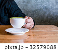 Asian man holding a cup of hot matcha latte.  32579088