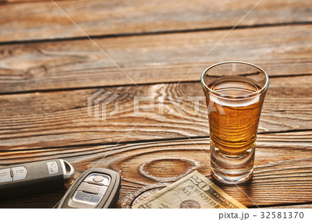 Glass of tequila or alcohol drink and car key Glass of tequila or alcohol drink and car key 32581370