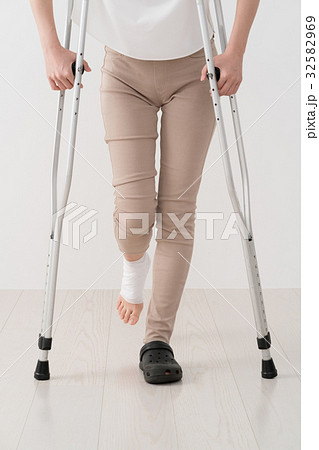 松葉杖を使う女性 足 怪我 包帯の写真素材