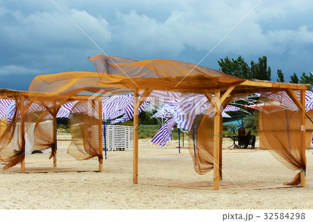 The wind on the beach shakes the canopy curtains The wind on the beach shakes the canopy curtains 32584298