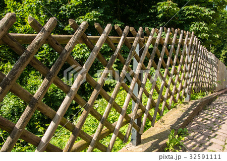 Beautiful wooden fence near the rural country path Beautiful wooden fence near the rural country path 32591111