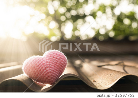 Pink heart knitting on roof in mornig sun. 32597755