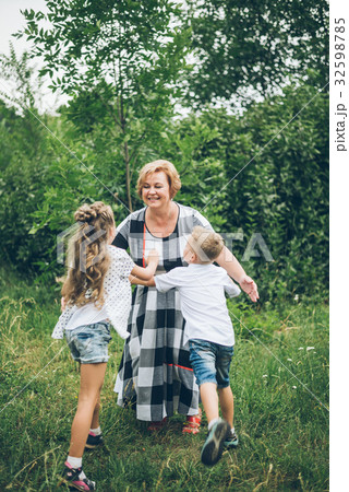 Grandmother playing in the park with grandchildren Grandmother playing in the park with grandchildren 32598785