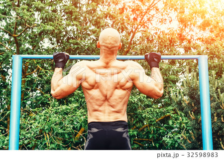 Closeup of strong bald athlete doing pull-up on 32598983
