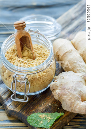 Ground ginger and scoop in a glass jar. 32599542