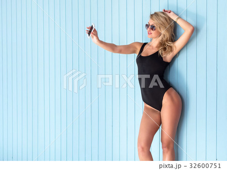 blonde woman in bodysuit with perfect body taking 32600751