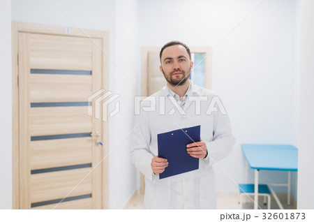Cheerful young doctor holding a clipboard and 32601873