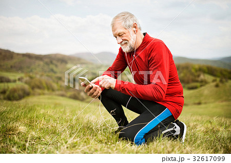 Active senior runner in nature with smart phone 32617099