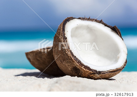 Broken brown coconut on sandy beach Broken brown coconut on sandy beach 32617913