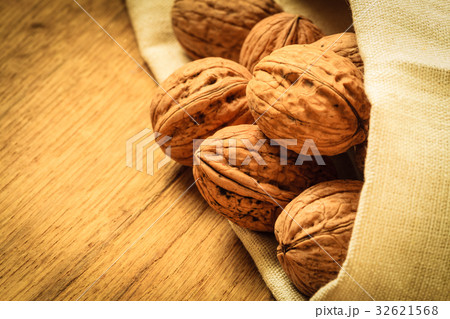 Whole walnuts on rustic old wooden table 32621568
