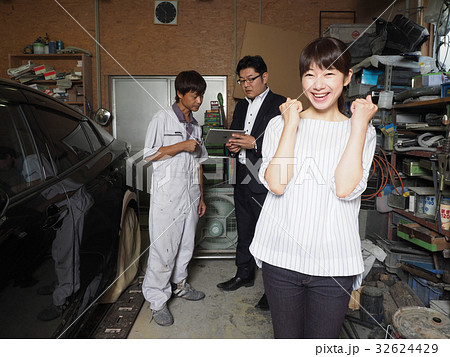 鈑金屋さんと保険屋さんの前で喜ぶ女性 32624429